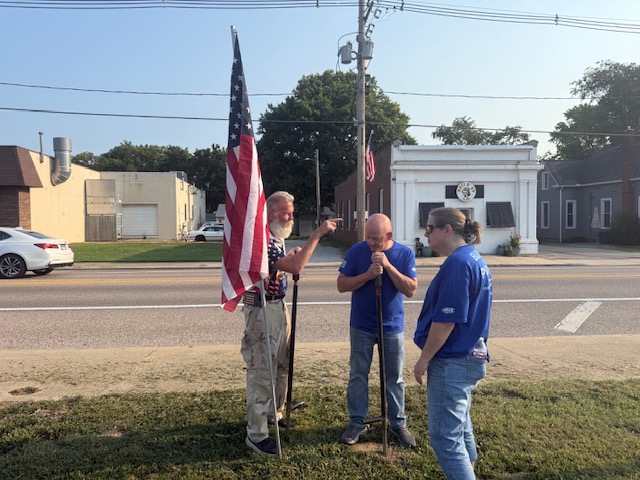 Volunteers placing flags along the road with The Flagman's Mission Continues.